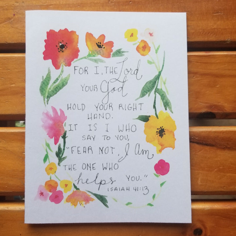 Card with floral design and Bible verse on a wooden surface