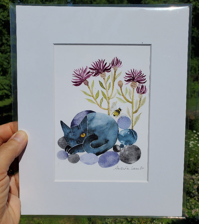 Framed artwork of a blue cat with flowers and a bee on a light blue background