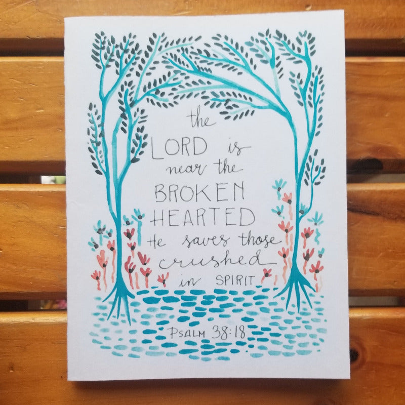 Card with artistic design of trees and text on a wooden surface