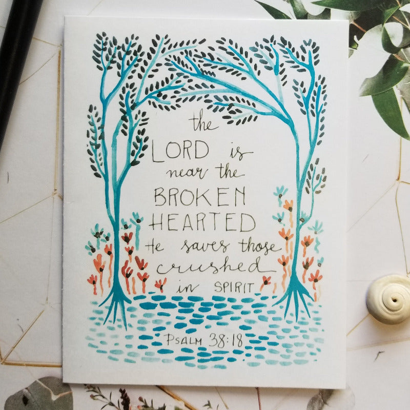 Card with artistic design and text on a decorative surface with plants.