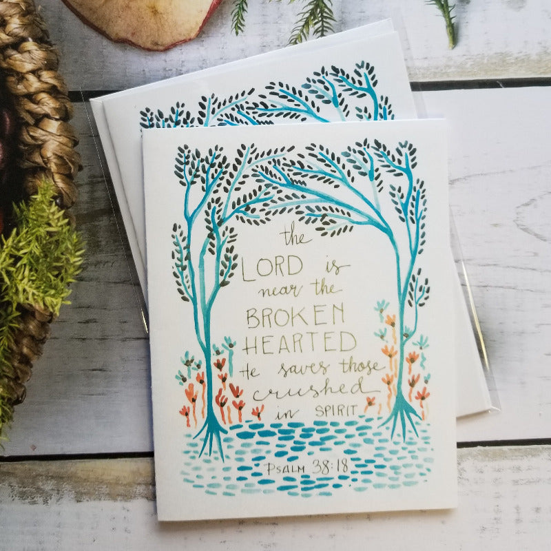 Card with decorative design and text on a wooden surface with natural elements.